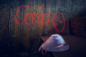 Symbolic picture, menekel on concrete wall, lettering Covid 19, handwriting with red laser beam, respirator Symbolic picture, menekel on concrete wall, lettering Covid 19, handwriting with red laser beam, respirator